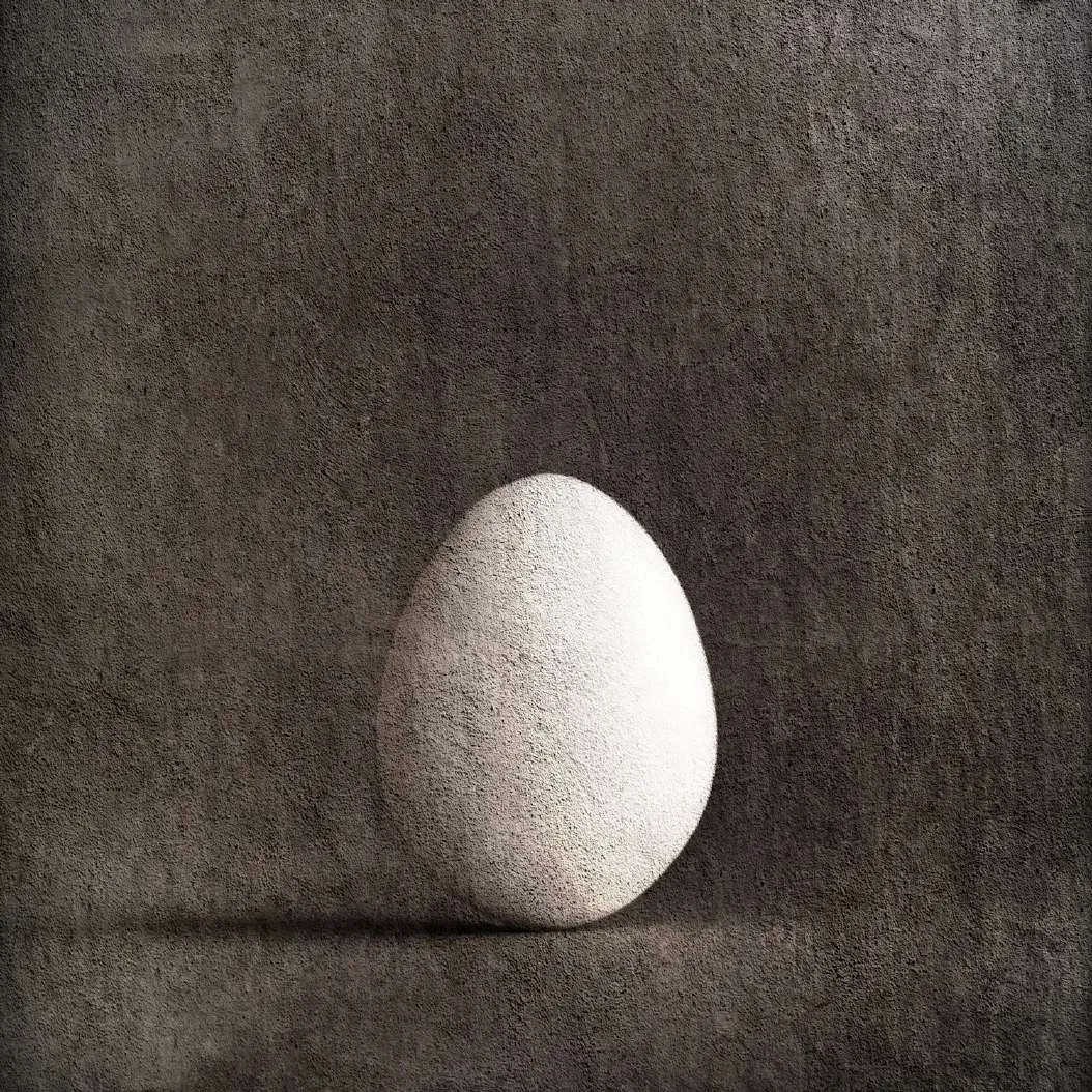 Huevo blanco sobre fondo gris texturado