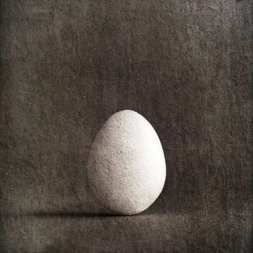 Huevo blanco sobre fondo gris texturado