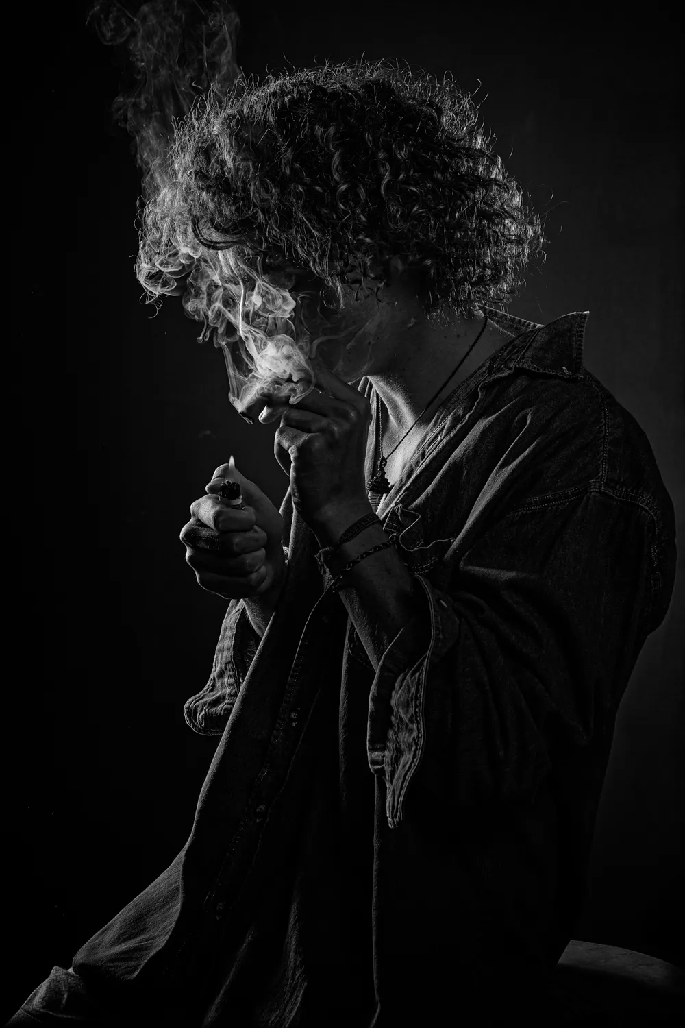 Persona a contraluz envuelta en humo, en blanco y negro