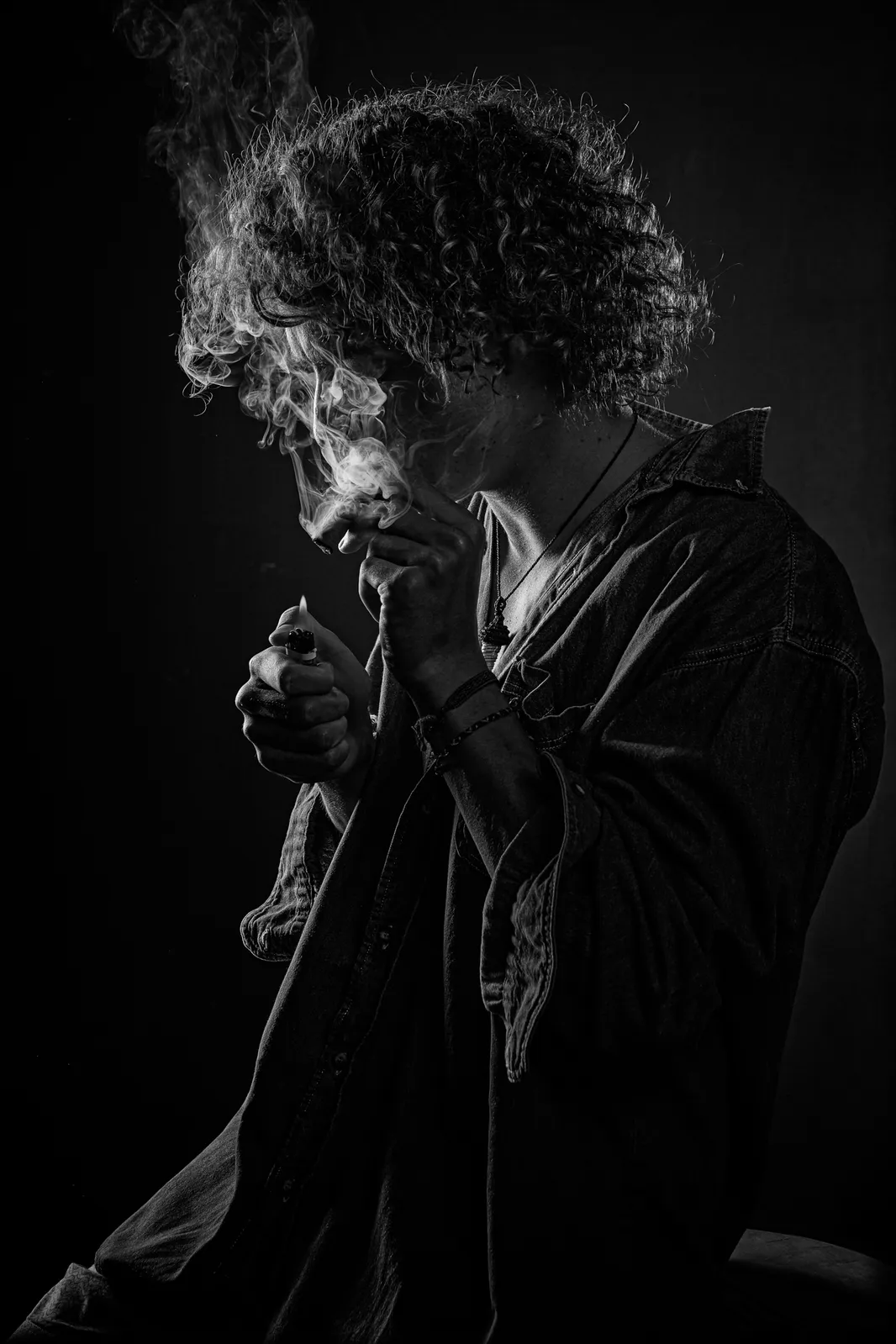 Persona a contraluz envuelta en humo, en blanco y negro