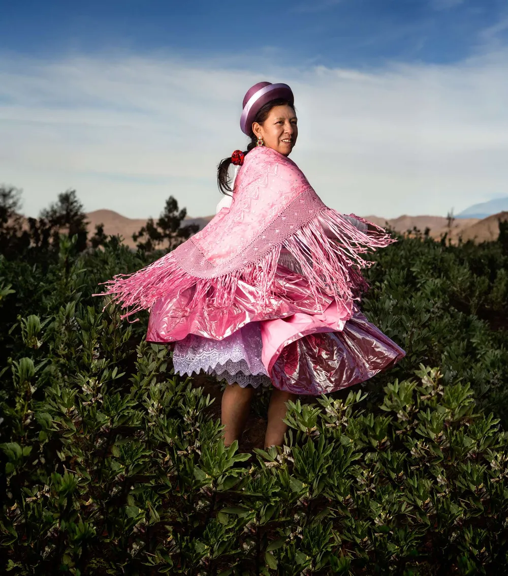 Niña con pollera rosada girando en un campo verde