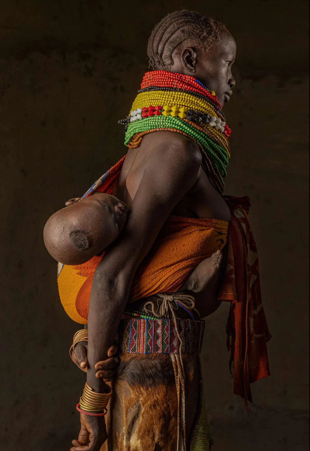 Mujer karo con un niño a la espalda